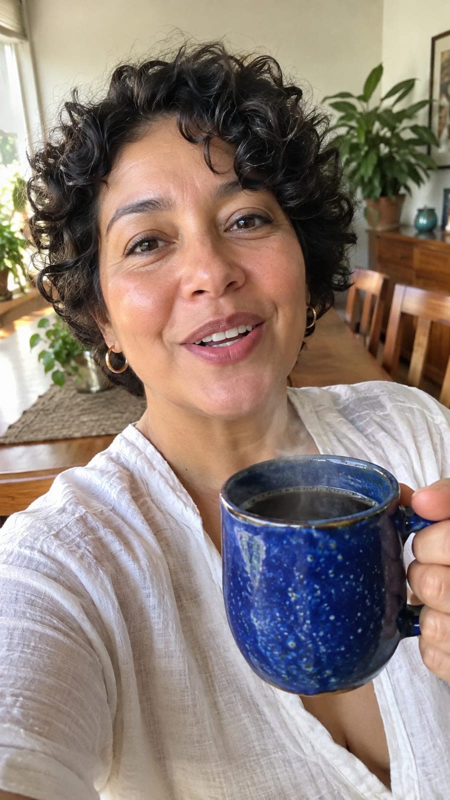 Mujer colombiana mostrando una taza de cerámica azul con café caliente
